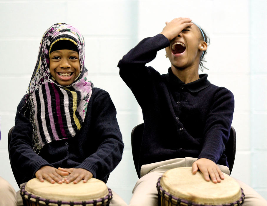 Feature - 2nd placeSixth-graders Fawzi Abdul, 11, (left) laughs as her classmate Nikiyah Simpson, 11,  tries to perform the drumming sequence correctly on "djembe" drums at Citizens Leadership Academy.  West African musician Sogbety Diomande, originally from Cote d'Ivoire, has been an artist in residence with Young Audiences of Northeast Ohio and has been working with the sixth-graders for about four weeks now on West African drumming. His workshop is called "Discover West African Rhythm and Culture".  Local schools have been celebrating Black History Month through theater, song, poetry, dance and art. (Lisa DeJong  / The Plain Dealer)