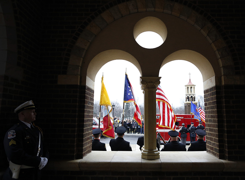 Columbus Police Honor Guard Sgt. Jim Morrow watches as the caskets of Westerville Police officers Joering and Morelli arrive at St. Paul Catholic Church for the funeral services in Westerville. (Kyle Robertson / The Columbus Dispatch)