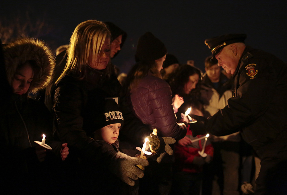 Grady Leighty, 5, shields his candle as his mother, Michelle, helps, during a community vigil for fallen Westerville Police officers Eric Joering and Anthony Morelli at First Responders Park in Westerville. The officers were killed following an ambush as they responded to a domestic violence call. Grady's dad is a police officer with the Westerville Police Department.  (Joshua A. Bickel / The Columbus Dispatch)