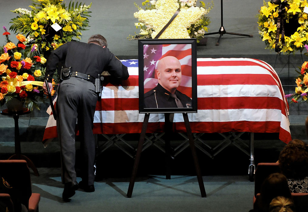 General News - 3rd place - Warren County Sheriff Larry L. SIms kisses the casket of fallen Warren County Sheriff's Sgt. Brian Dulle inside Christ's Church at Mason for his funeral  in Mason. (Marshall Gorby / Springfield News-Sun)