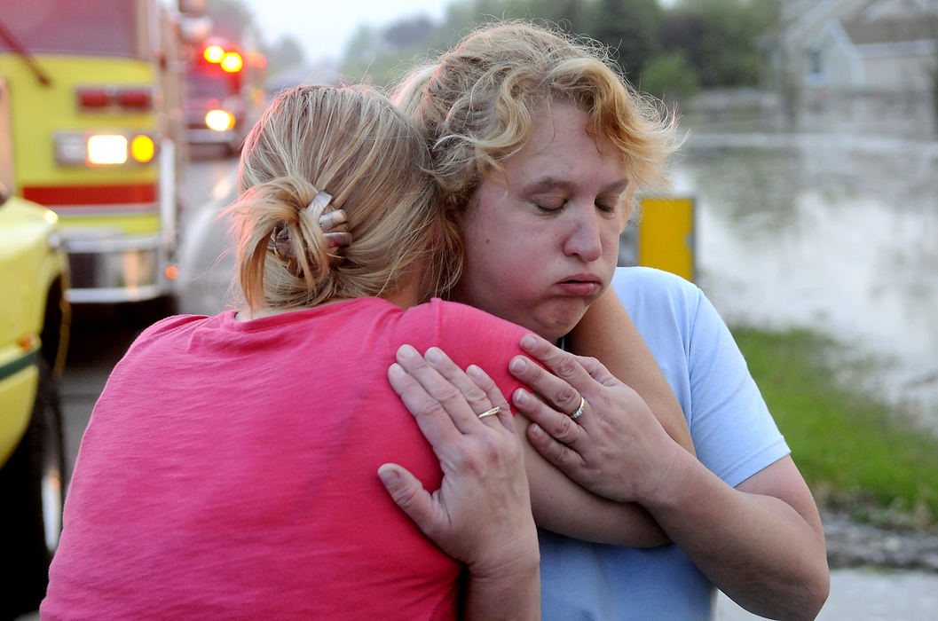 Spot News - HM - Neighbors hug after being rescued by members of the Springfield Twp. Fire Division from their homes along South Charleston Pike after flood waters surrounded their house following a heavy thunderstorm.  (Marshall Gorby / Springfield News-Sun)
