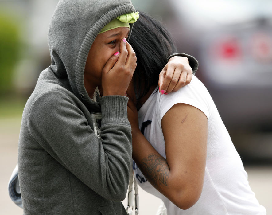 Spot News - 1st placeTwo young women hold each other after learning the names from the double homicide in or near the Northland Arms complex north of Morse Road in Columbus. The two women both dated one of the two men that were killed. (Kyle Robertson / The Columbus Dispatch)