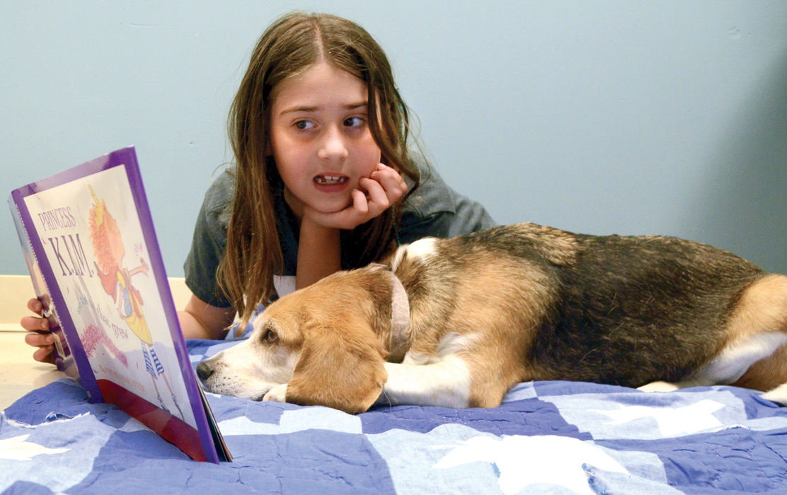 General News - HMNine-year-old Lexi Blakeman reads “Princess K.I.M.” to Henry the beagle, a TailWaggin’ Tutor at Joshua Dixon Elementary in Columbiana. (Patricia Schaeffer / The (Lisbon) Morning Journal)