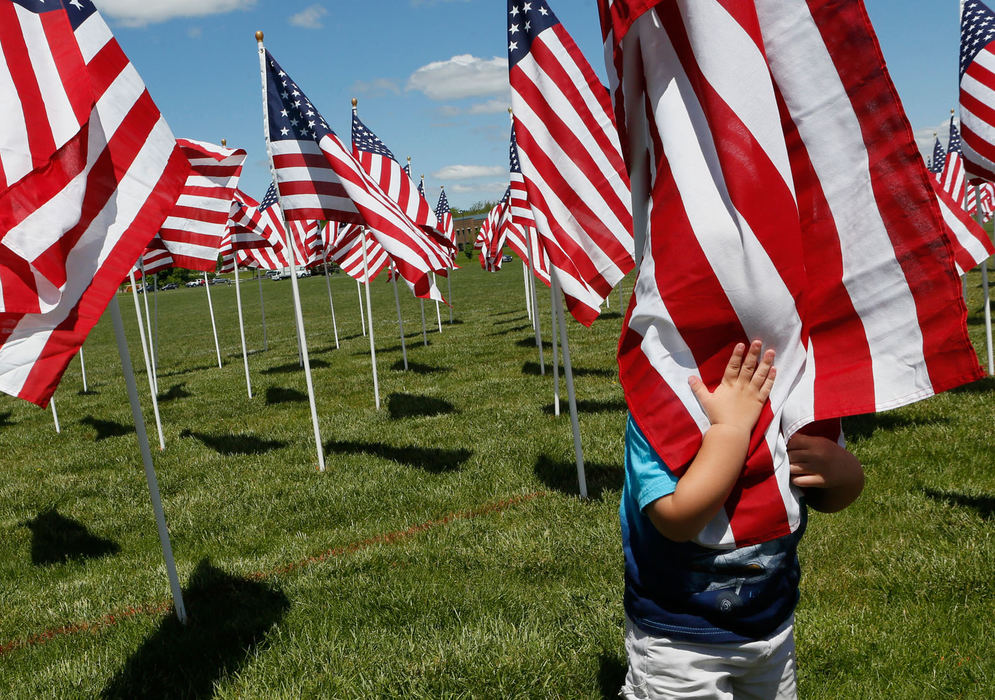 Feature - HM - Kenton Reckziegel of Pickerington hides while his grandma Sabine Rivers of Blacklick tries to take his photo at the Field of Heroes flag display. (Eric Albrecht / The Columbus Dispatch)