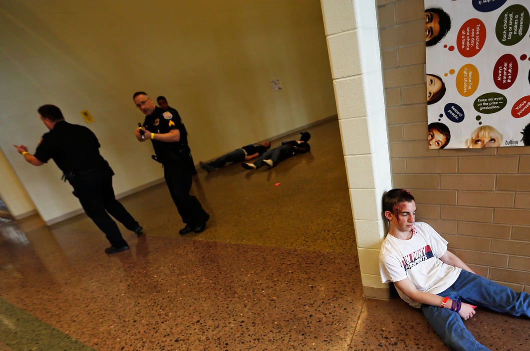 General News - HM - Anthony Mascari, a criminal justice student at C-Tec (Career and Technical Education Centers of Licking County), pretends to be injured as Reynoldsburg police officers check the scene during a staged emergency response drill at Reynoldsburg High School. (Jonathan Quilter / The Columbus Dispatch)