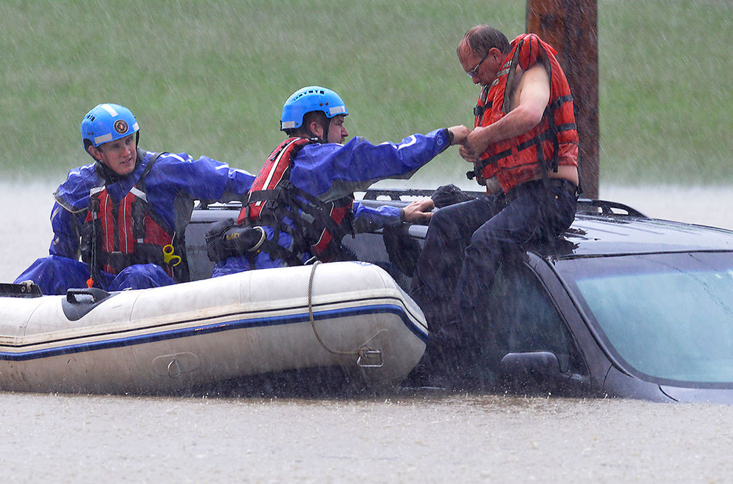 Spot News - 3rd place - Members of the Huber Heights Water Recovery Team rescue a stranded motorist from the roof of his car after it became submerged in several feet of water during a storm. The motorist drove around a fire engine blocking the intersection of Gerlaugh Road and Ohio 235 and became stranded.  (Bill Lackey / Springfield News-Sun)