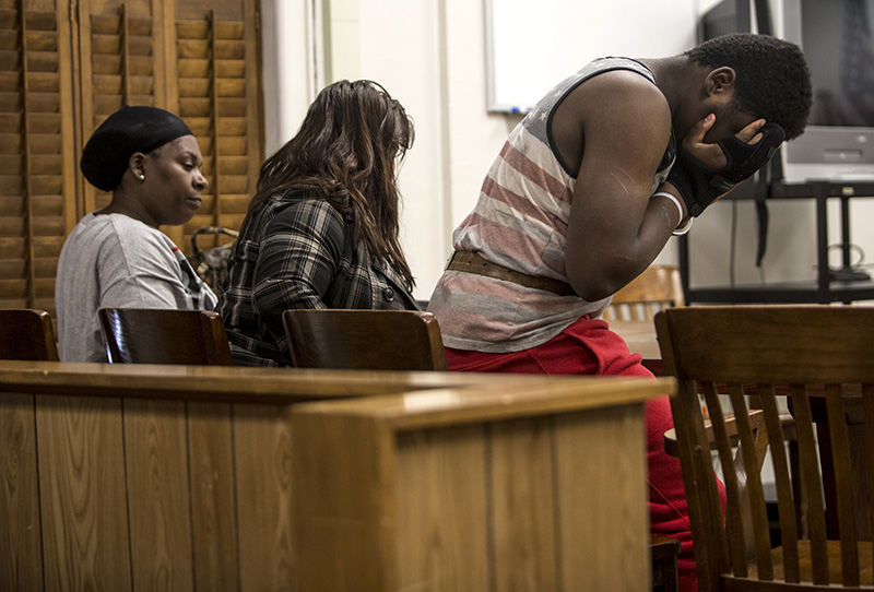 General News - 2nd place - Prophet Johnson, 13, (right) covers his face as he exits a Licking County Juvenile courtroom. Johnson was ordered to be held in the Multi-County Juvenile Detention Facility in Lancaster after being charged with one count of complicity to aggravated robbery, a first-degree felony equivalency account, and aggravated riot, a fourth-degree felony at a house party in Utica. (Jessica Phelps / Newark Advocate)