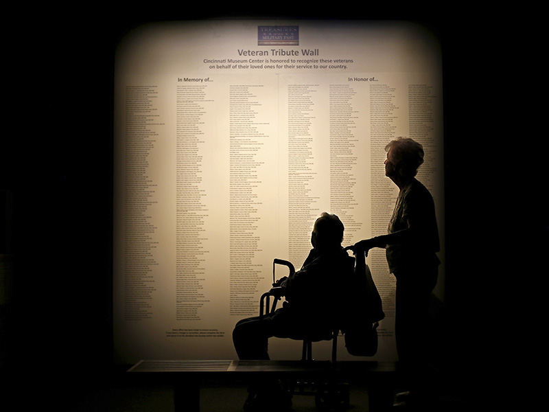 AGeneral News - 3rd place - World War II Army veteran of the 102 Infantry Division, Noel Brotherton, 92, and his wife Pat Brotherton, 88, of Sharonville take a moment to read names on the Veteran Tribute Wall at the new "Treasures of Our Military Past" exhibit at the Cincinnati Museum Center. The military exhibit features pieces of military history dating back to the Revolutionary War. (Sam Greene / Cincinnati Enquirer)