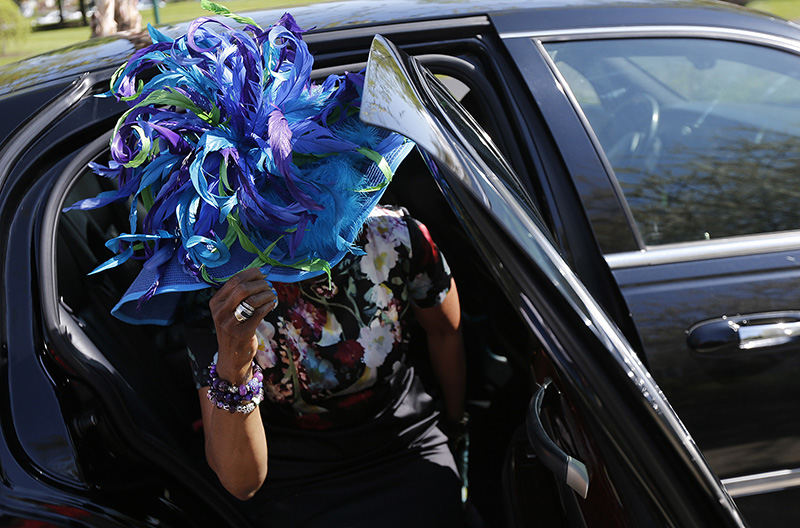 General News - HM - Charlotte Rhea, of the East Side, gently maneuvers her hat out of a the car as she arrives during the 15th annual Les Chapeaux dans le Jardin, or "Hat Day," at Franklin Park Conservatory. Rhea called her hat "color explosion" and said it made her think of Mardi Gras. The annual spring fundraiser at the Conservatory brings together a few hundred guests in all sorts of hats imaginable to raise more than 3.3 million dollars over 15 years for the Conservatory's education programs.  (Eamon Queeney / The Columbus Dispatch)