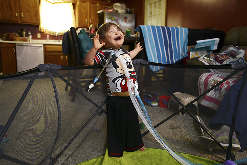 Portrait - 1st place - Sebastian Longstreth dances in his play pen in his South Zanesville. The three year old has overcome a host of medical difficulties, including a decreasing dependance on his breathing tubes. (Chris Crook / Zanesville Times Recorder)