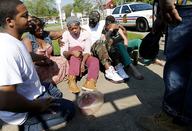 Spot News - 1st place - A sobbing Lavon Logan (third from left) is consoled by family members after Columbus Police removed her brother's body during the investigation of the fatal shooting at 368 N. Roosevelt Ave. on the East Side near Bexley.  (Eamon Queeney / The Columbus Dispatch)