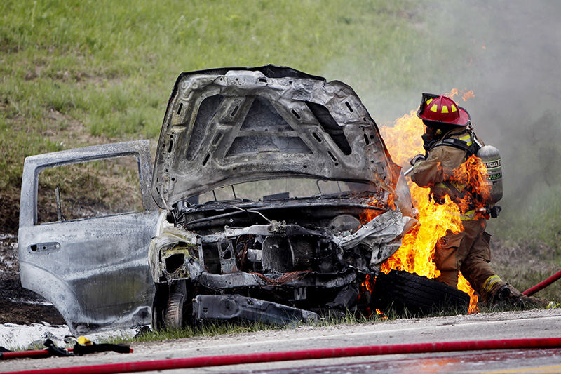 Spot News - 3rd place - Brian Hurst, a Milan Township fireman, is surrounded in flames as a car fire flares up due to a gas leak on Mason Road in Huron. Amber Kryger, of Milan, and her four children escaped from the vehicle before it caught fire following an accident. (Angela Wilhelm / Sandusky Register)