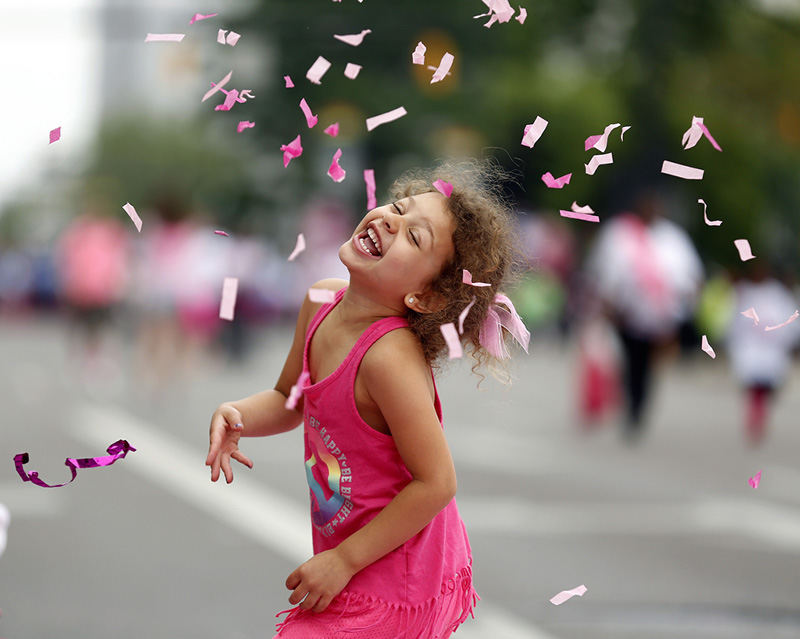 Story - 2nd place - Mayya Jewett, 5, throws up confetti as she waits for the start of the Family Fun Walk during the 2015 Komen Race for the Cure in downtown Columbus. (Kyle Robertson / The Columbus Dispatch )