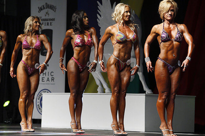 Story - 1st place - Angi Lampkin, 44, of Florence (second from left) and Michelle Reynolds-Madden 40, of Fort Thomas (third from left) show their muscles for judges during the fifth annual Kentucky Derby Festival Championships of Bodybuilding at the The Kentucky International Convention Center in Louisville. The competition was a first for the two Northern Kentucky women. (Cara Owsley  / Cincinnati Enquirer)