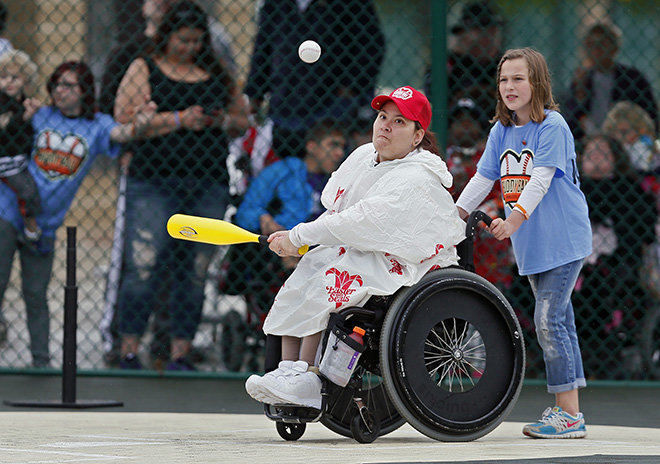 Story - 2nd place - Amber Salsburey of the Reds connects for a hit during the first ever game at Mirolo Dream Field at Windsor Park in Grove City. Grove City raised almost $600,000 to build a rubberized Little League baseball field so children of all ages and abilities can safely play baseball.   (Kyle Robertson / The Columbus Dispatch)