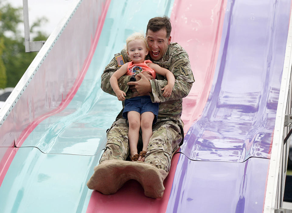 NEFeature - 2nd place - Vince Grady, of Pataskala, rides down the Fun Slide with his daughter, McKena, 3, during New Albany's Founders Day festival. (Shane Flanigan / ThisWeek Newspapers)
