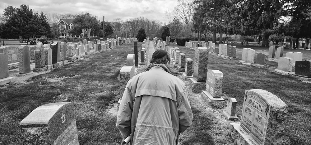    Feature - HM - Eden Feldstein, who was the last president of the Toledo Jewish Cemetery Association before it was dissolved earlier this year, walks through Anshai Sfard Cemetery in Rossford. (Jeremy Wadsworth / The (Toledo) Blade)