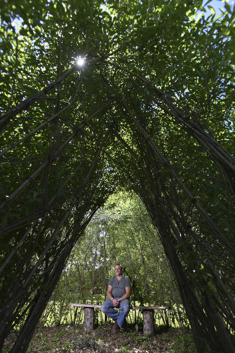 Portrait - 3rd place - Howard Pellar sits in a living landscape on his farm in Roseville. The dome-like structure is made of willow, planted and woven together. (Chris Crook / Zanesville Times Reocorder)