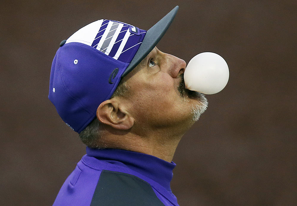 Sports Feature - HM - Jackson third-base coach Ross Vukovich blows a bubble while watching a fly ball hit by Green during the third inning on at Jackson High School. (Leah Klafczynski / Akron Beacon Journal)