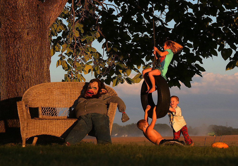 First Place, Feature - Eric Albrecht / The Columbus DispatchViolet Spangler, 5, gets a push from her brothers Paul, 7, and Julian, 4, at their rural home near Galloway. Parents John And Tiffany Spangler said its almost all nonstop play outside this fall until the sun sets. 