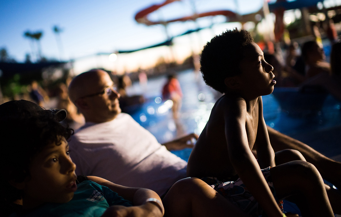 Third Place, Feature - Isaac Hale / Ohio UniversityOscar Paparone, right, 8, sits forward as he watches "Alexander and the Terrible, Horrible, No Good, Very Bad Day" with is family as part of the Dive 'n' Movies series at Wet 'n' Wild Phoenix waterpark in Glendale, AZ. The park plays a different movie every Thursday and Friday night.