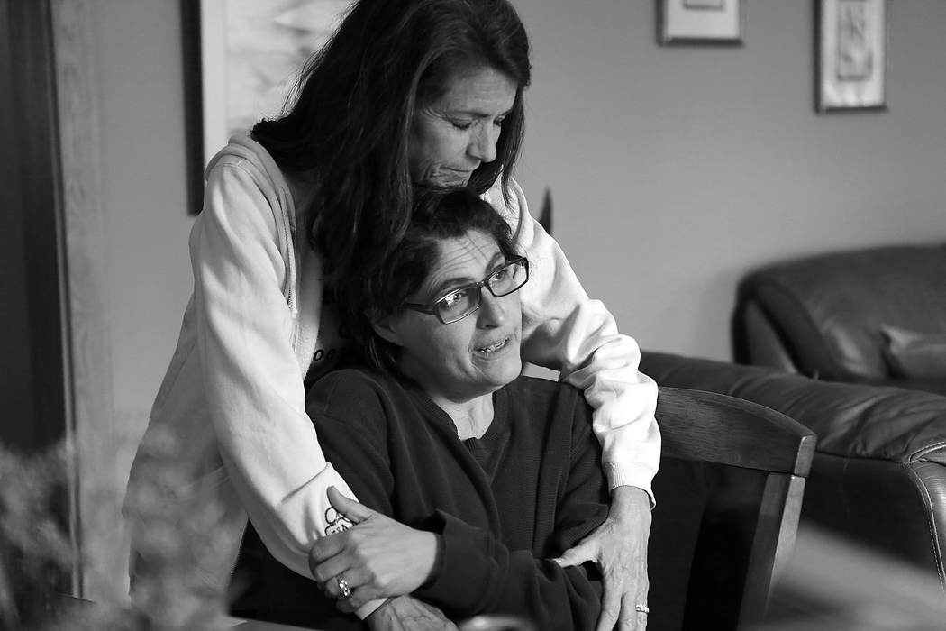 Second place, Feature Picture Story - Carrie Cochran / Cincinnati EnquirerApril 21 2015: Joe's sister, Diane Rose consoles Laurie as the hospice nurse cares for Joe upstairs.