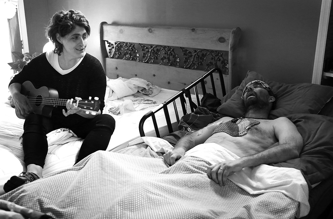 Second place, Feature Picture Story - Carrie Cochran / Cincinnati EnquirerApril 23, 2015: In Joe Neyer's final hours, his wife Laurie sings, "Dirty Knees," a song she wrote about him. Two and a half years earlier, Neyer was diagnosed with glioblastoma multiforme, the most aggressive form of brain cancer. Months after his diagnosis, he decided that he will not get treatment. "By accepting death, you can actually enjoy life," he said. 