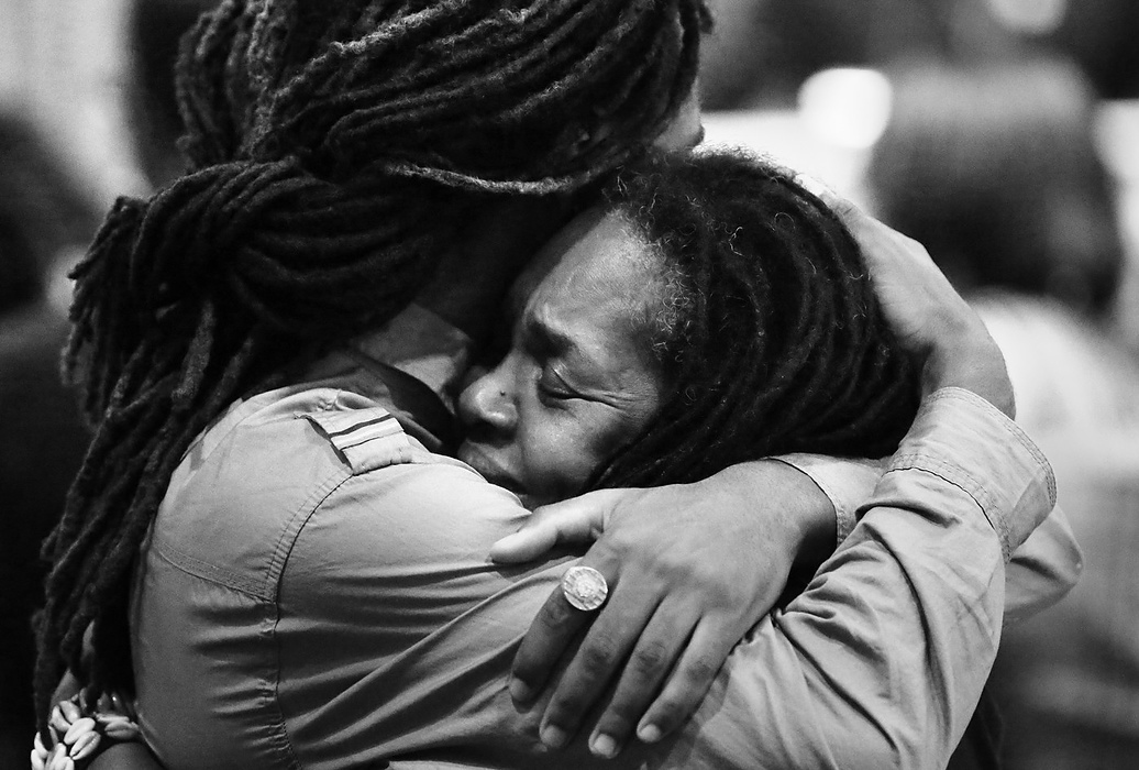 First Place, News Picture Story - Carrie Cochran / Cincinnati EnquirerFuneral attendees embrace before the service for Samuel DuBose. DuBose was the unarmed Cincinnati man who was shot and killed by University of Cincinnati police officer Ray Tensing during a traffic stop on July 19 in Mount Auburn.