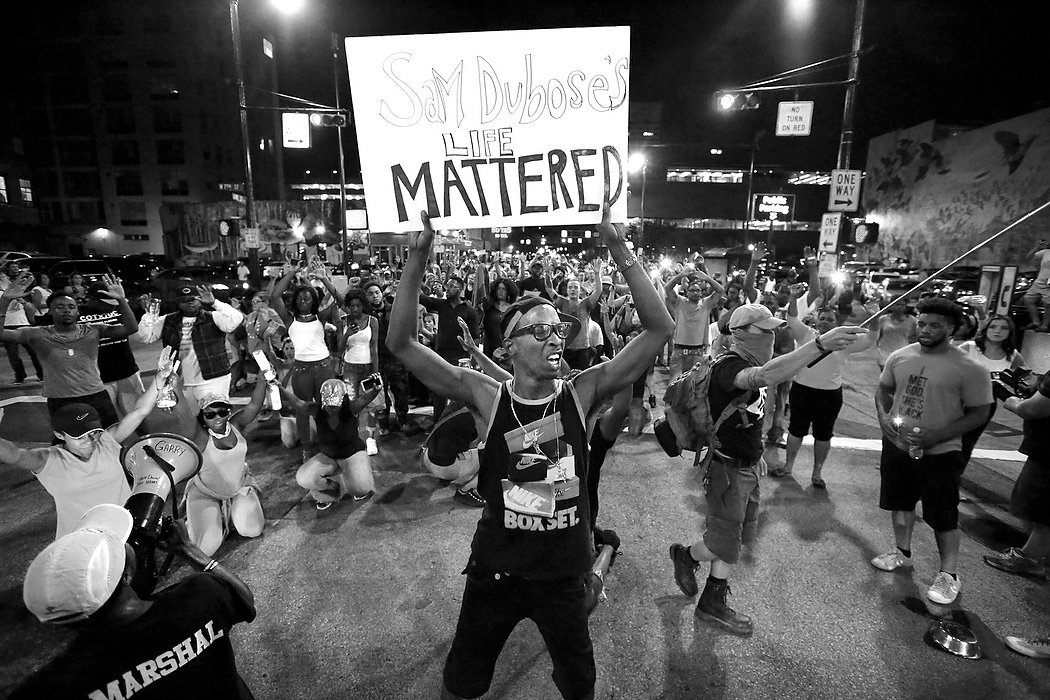First Place, News Picture Story - Carrie Cochran / Cincinnati EnquirerMarchers stop at the intersection of Seventh and Vine Streets, saying "hands up, don't shoot." A vigil for Samuel DuBose turned into a march, the through the streets of Over-the-Rhine and Downtown Cincinnati.