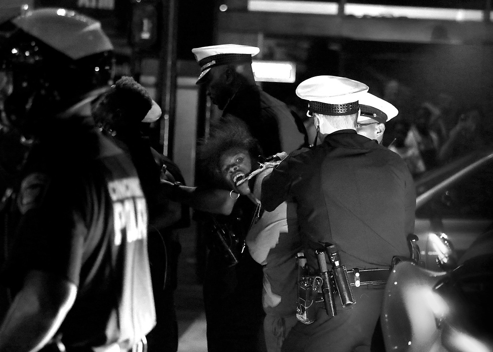 First Place, News Picture Story - Carrie Cochran / Cincinnati EnquirerKimberly Thomas of Clifton is arrested in front of Fountain Square Friday night after a vigil for Samuel DuBose, turned into a march through the streets of Over-the-Rhine and Downtown Cincinnati. Six people were arrested during the march, which DuBose's family disowned after a peaceful candlelight vigil. Cincinnati police Captain Doug Wiesman said officers made an initial arrest because an individual threatened a business in Over-the-Rhine. While arresting the first individual, other demonstrators tried to obstruct justice, he said.
