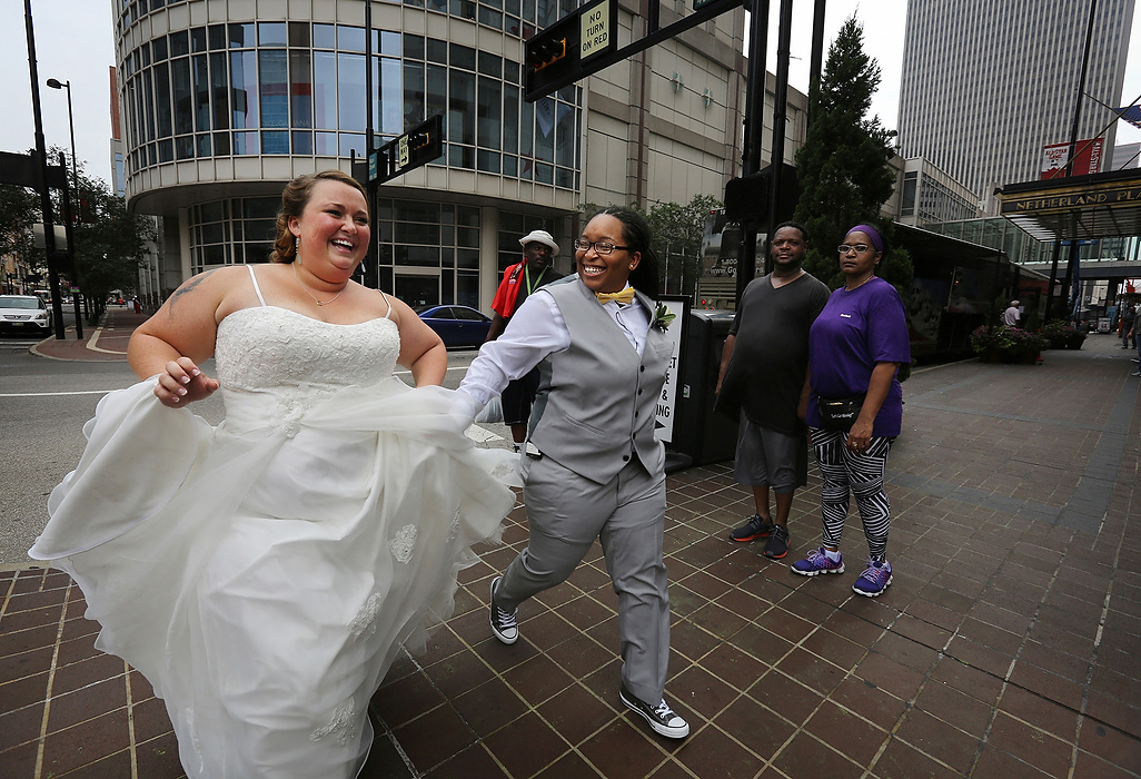 First Place, Photographer of the Year - Large Market - Carrie Cochran / Cincinnati EnquirerOnlookers watch as Chelsey Madden and Christian Wright, both of Colerain Twp., Ohio, run to the their wedding ceremony after posing for some photos with their photographer. Gay marriage became legalized a month earlier. 