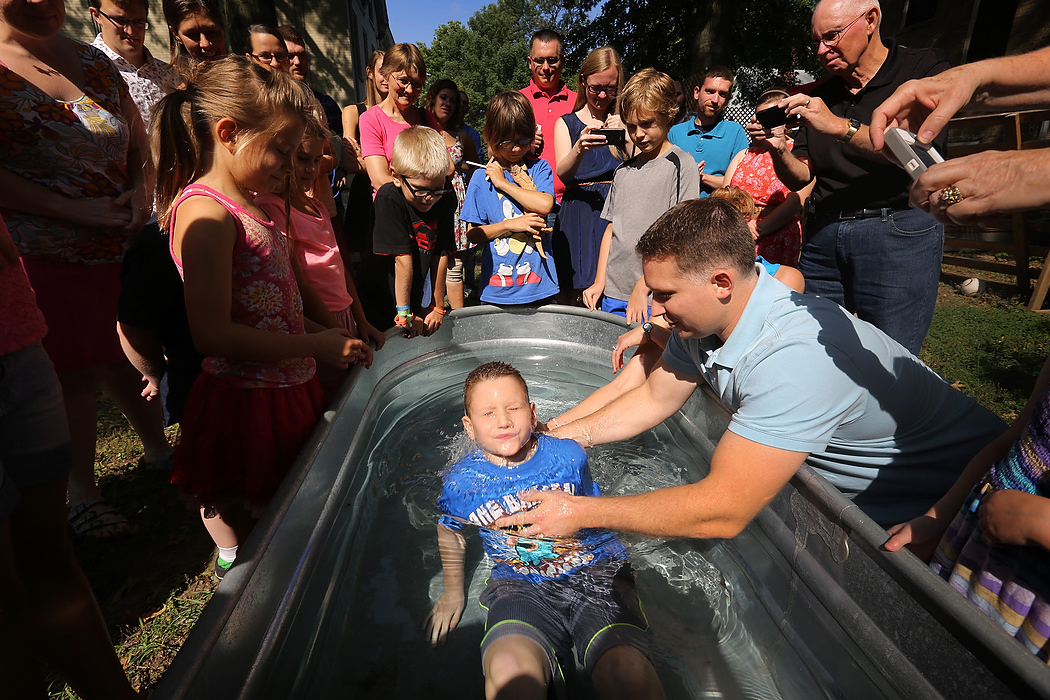 First Place, Photographer of the Year - Large Market - Carrie Cochran / Cincinnati EnquirerEthan Bruner of Norwood, 8, is baptized by his dad, Mark, after Vineyard Central's services at the old St. Elizabeth Church in Norwood. The grassroots church is housed in an old Catholic church.