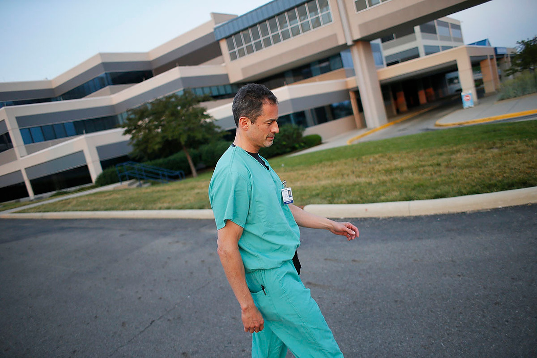 Second Place, Photographer of the Year - Large Market - Adam Cairns / The Columbus DispatchAfter completing his morning rounds at 6 a.m., Orthopedic surgeon Brian Cohen walks between buildings at Adena Health System before starting his operation schedule, which included seven procedures, on June 10, 2015. After sleeping five to six hours a night, Cohen typically begins his work day at 3 a.m. He works out for an hour before commuting 60 miles from his Columbus-area home to Chillicothe. As one of the nation's highest-paid physicians practicing at a nonprofit or public hospital, Cohen cites his skill and robotic-like discipline to justify his lofty paycheck.