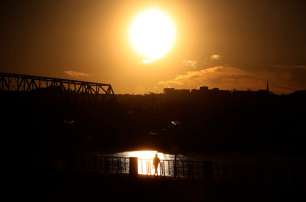 First Place, Photographer of the Year - Large Market - Carrie Cochran / Cincinnati EnquirerA man walks along the Ohio River at Smale Riverfront Park at sunrise.