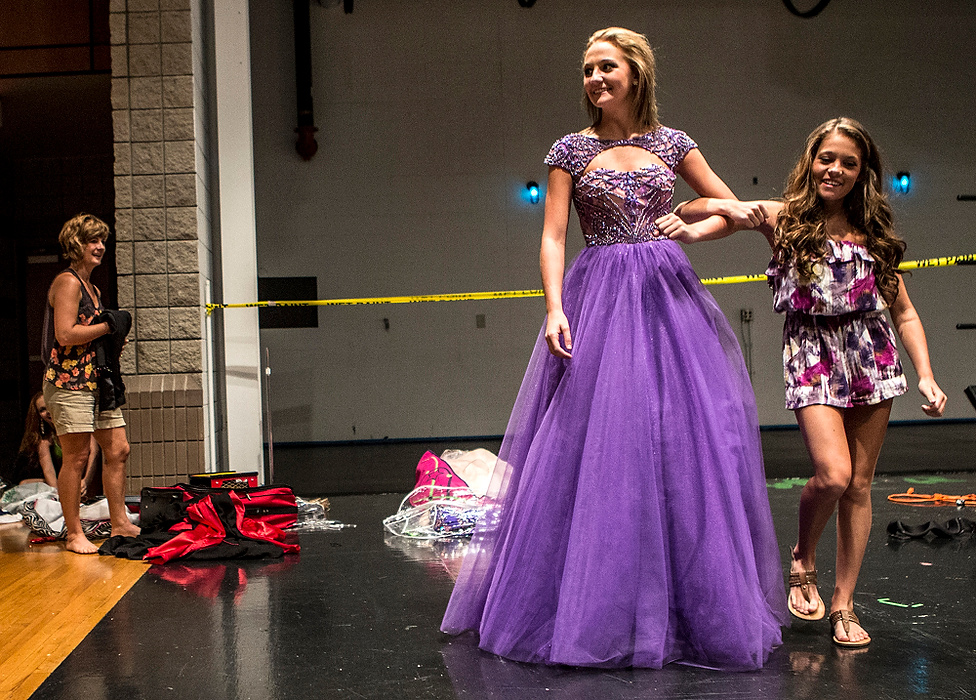 First Place, Photographer of the Year - Small Market - Jessica Phelps / Newark AdvocateAbby Hitchens laughs as she escorts her sister, Katie, across the stage while the sisters rehearse for the Miss Outstanding Teen competition. Abby who is the older sister is also much shorter than Katie. 