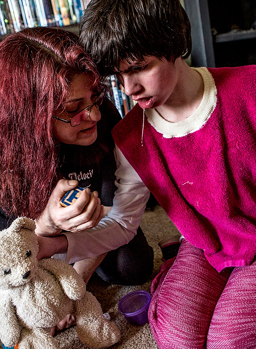 First Place, Photographer of the Year - Small Market - Jessica Phelps / Newark AdvocateBonnie Rinato sits on the floor and plays with her daughter, Katie Lapenta after returning from school. Rinato is the home health care aide for her daughter who is now 25 and has developmental disabilities. 
