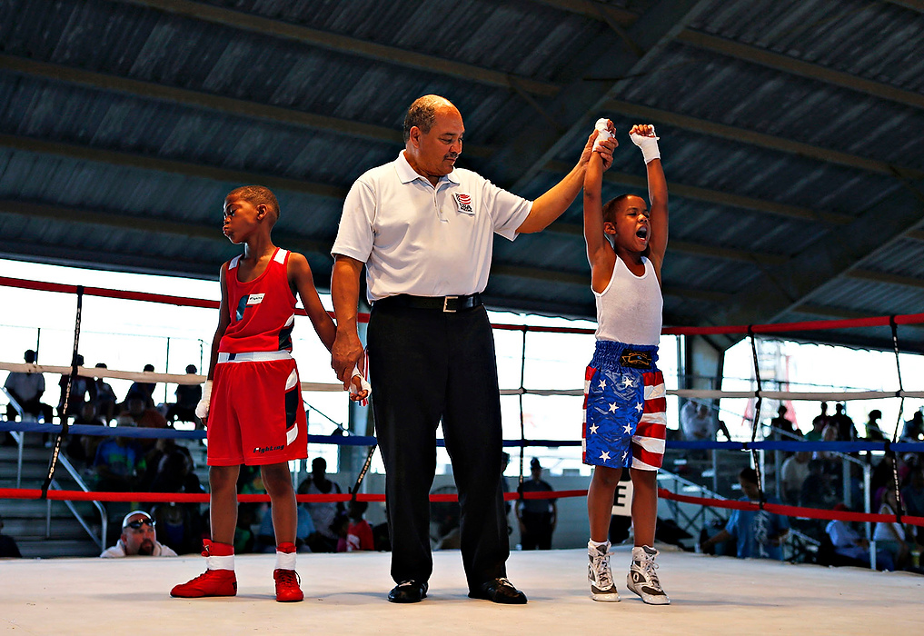 Third Place, Sports Feature - Leah Klafczynski / Kent State UniversityRicky Lasley of Dayton (right) cheers after defeating Joshua Knuckles (left) of Cleveland during the Amateur PeeWee Boxing Tournament at The Ohio State Fair.