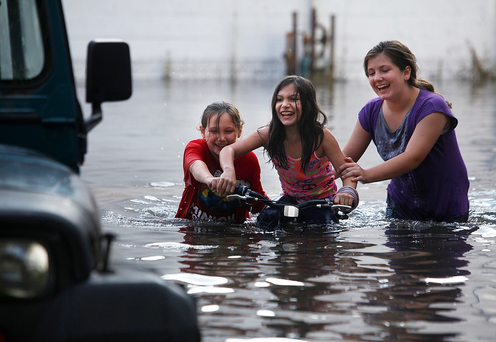 , Student Photographer of the Year - Eli C. Hiller / Ohio UniversityIzzy Gruber, 8, and Addy Vanvorhis, 12, push their younger sister Gabby Gruber, 8, through a flooded parking lot on her bike they had just found in Johnstown Ohio, on August 9, 2015. Many neighborhood kids play in the lot and they lost their toys when heavy rain flooded the parking lot earlier that afternoon. The local drainage system was not working properly due frequent rains that affected most of the Midwest during June and July.