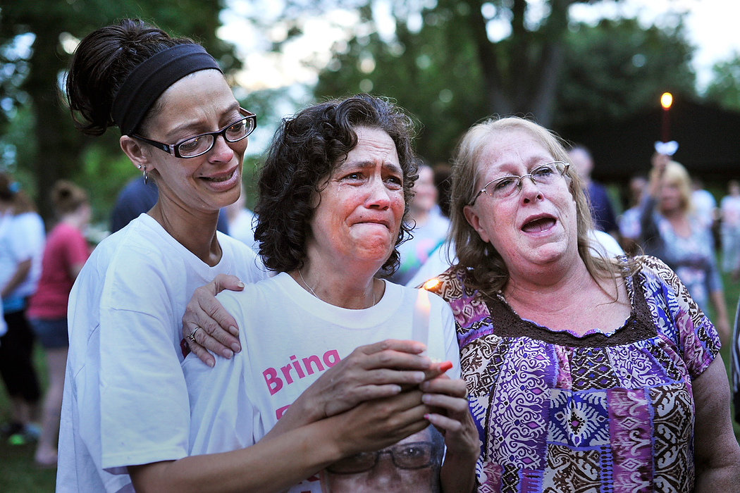 , Student Photographer of the Year - Eli C. Hiller / Ohio UniversityCenter, Angela Robinson, 50 of Chillicothe, is comforted by Chastity Lett, left, and family friend Lynette Mitchell while people sing a prayer song during the vigil for the missing  and deceased women in Chillicothe in Yoctangee Park on June 4, 2015. Robinson's daughter Tameka Lynch, 30, went missing May 16, 2014 and was found dead May 26, 2014.