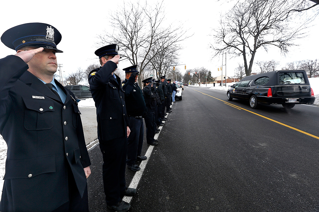 First Place, Team Picture Story - Amy E. Voigt / The (Toledo) BladeToledo Police Officer Paul Toth stands at attention with members of the Toledo Police Department while the body of Mayor D. Michael Collins passes the TPPA Hall on its way to Rosary Cathedral onFebruary 12, 2015.