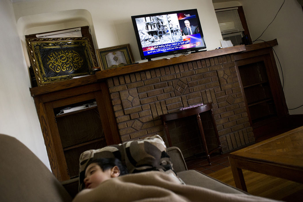 Award of Excellence, Feature Picture Story - Eslah Attar / Kent State UniversityNews on the conflict in Syria is broadcast on the television while Mohamad sleeps in his home. 