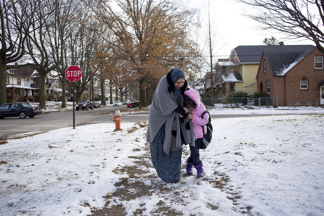 Award of Excellence, Feature Picture Story - Eslah Attar / Kent State UniversityMariam helps her daughter Baisan navigate the precarious and icy sidewalks as they walk home from the school bus. 