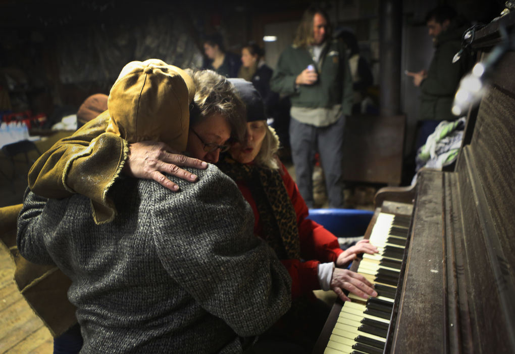 First Place, News Picture Story - Carrie Cochran / Cincinnati EnquirerRabbit Hash Historical Society board member Bobbi Kayser, center, gets a hug as supporters play 'Amazing Grace' early Sunday morning while a fire destroys the iconic Rabbit Hash General Store.
