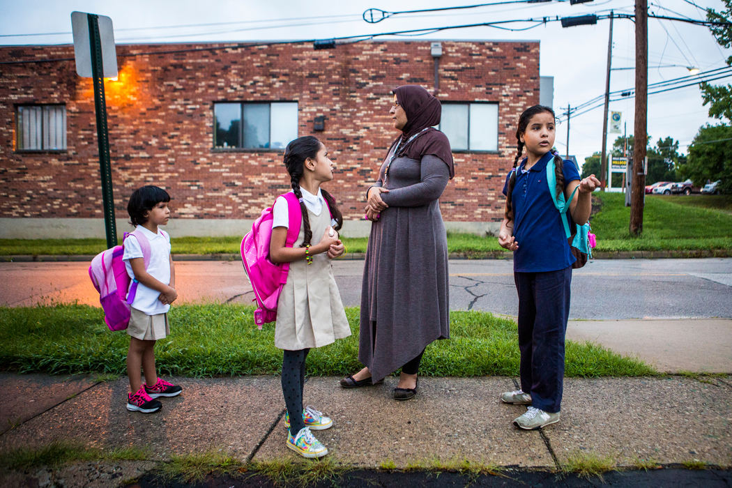 Second Place, James R. Gordon Ohio Understanding Award - Meg Vogel / Cincinnati EnquirerRimas, Zina, and Dalal Alhamoud wait with their mother, Ahlam, at the bus stop for their first day of school Wednesday, August 17, 2016. It was Rimas' first day of school ever. She is in kindergarten. Volunteers raised money to buy all the kids school supplies.