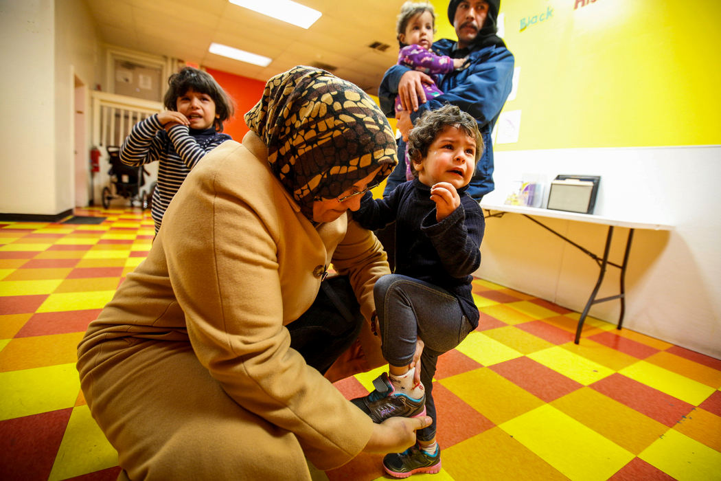Second Place, James R. Gordon Ohio Understanding Award - Meg Vogel / Cincinnati EnquirerAhlam Ahlamoud adjusts the shoe of Ghalia while dropping the three youngest children off for their third day of day care on Friday, February 19, 2016.