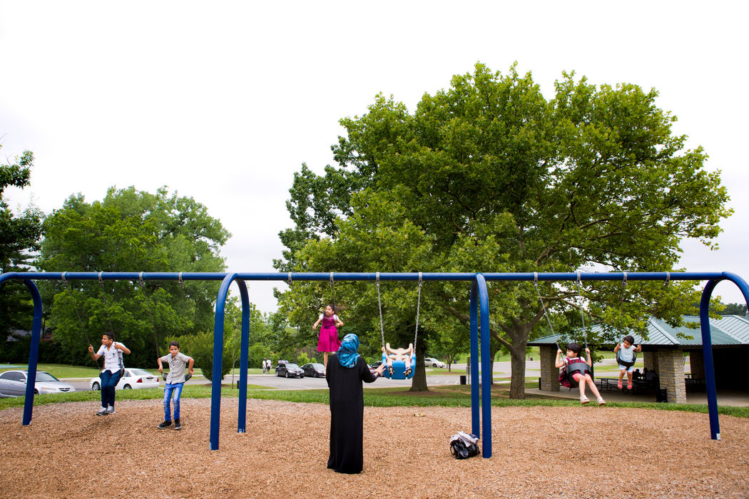 Second Place, James R. Gordon Ohio Understanding Award - Meg Vogel / Cincinnati EnquirerAhlam pushes her children on the swings at a local park, after an Eid al-Fitr celebration at Catholic Charities Thursday, July 7, 2016.