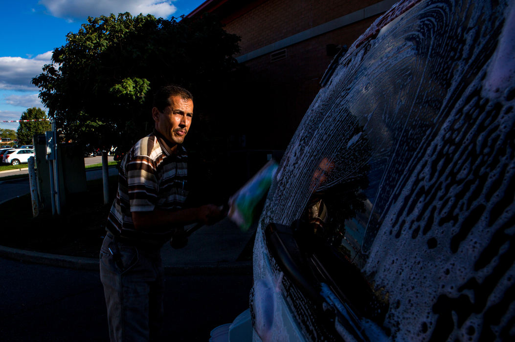 Second Place, James R. Gordon Ohio Understanding Award - Meg Vogel / Cincinnati EnquirerMarie Alhamoud washes a car that was recently sold at the car dealership he works at in Northern Kentucky on Thursday, October 13, 2016. Marie struggled to find work for the first six months in America. He has been working as a car lot technician since June. When his English skills improve, he will be able to move up in the company. 