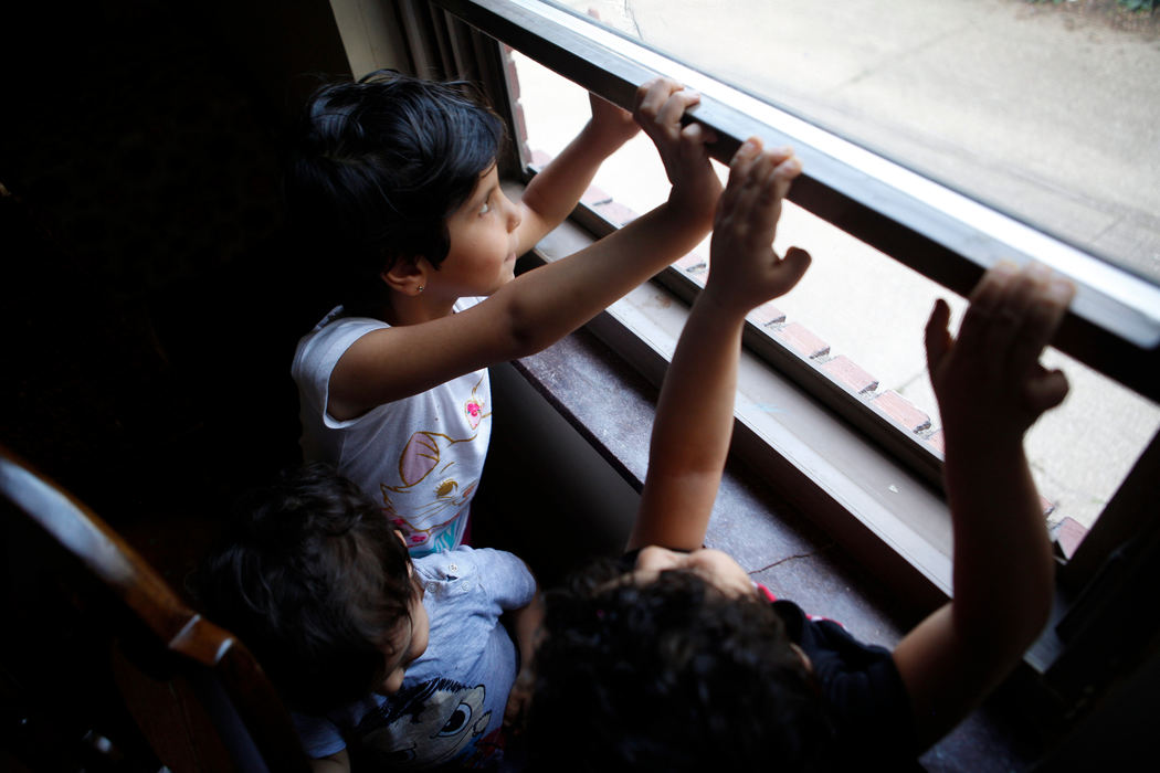 Second Place, James R. Gordon Ohio Understanding Award - Meg Vogel / Cincinnati EnquirerRimas, Yousif and Ghalia look out the window, as their mother, Ahlam, prepares dinner.