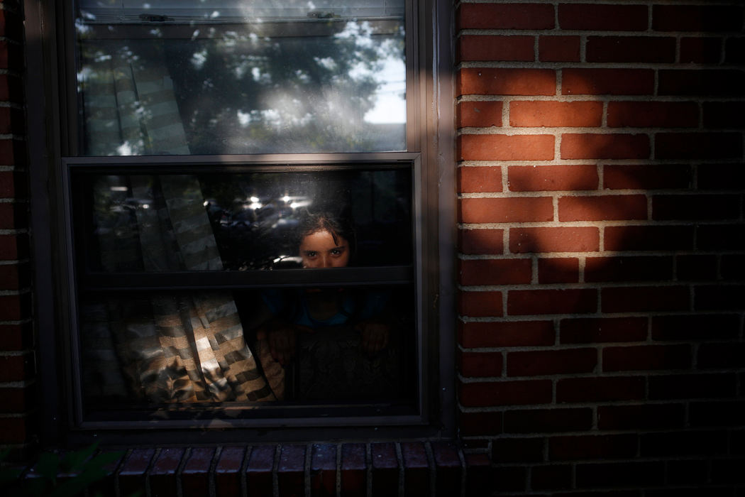 Second Place, James R. Gordon Ohio Understanding Award - Meg Vogel / Cincinnati EnquirerDalal Alhamoud, 9, looks out the window of her home Tuesday, May 24, 2016. She wants to be a math teacher. Dalal's family were the first Syrian refugees to be relocated to Cincinnati. They arrived in the United States on October 19, 2015, from Jordan, where they sought refuge for several years after fleeing Syria.  Dalal's dad, Marie said, "I wish they will have a better life than I had. Thank God, seeing my kids studying and learning in school is the best thing that is happening in my life.”