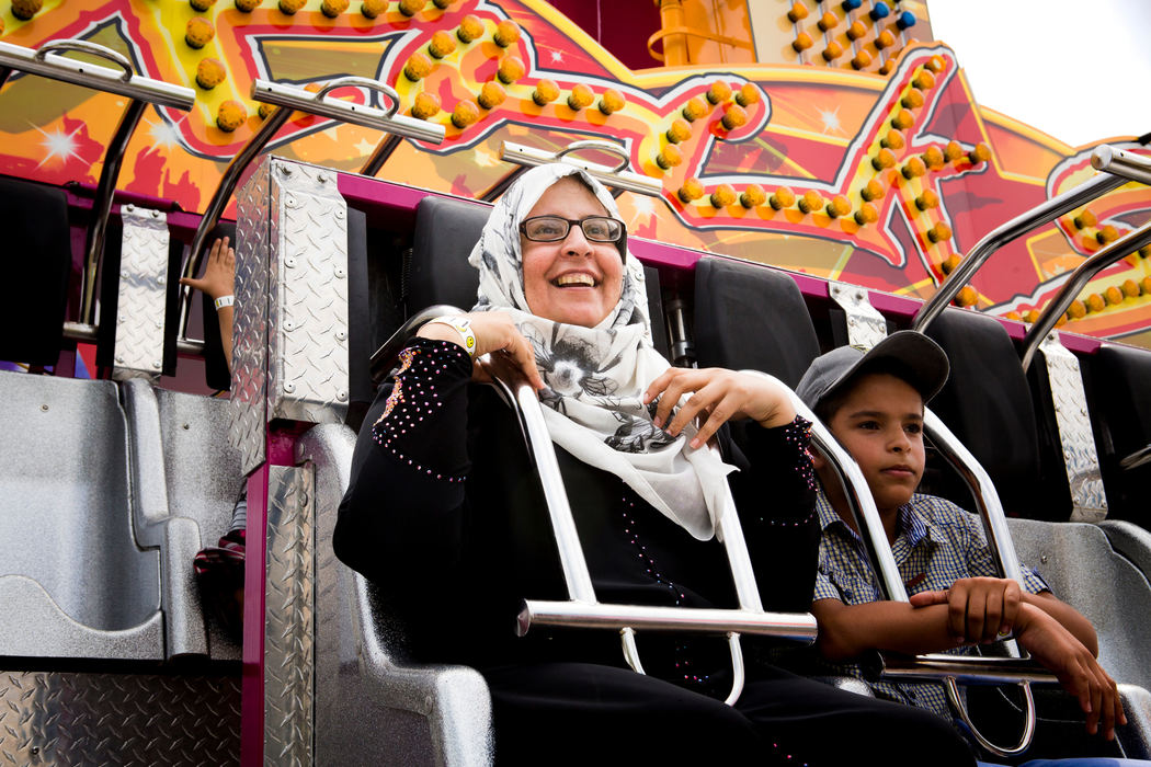 Second Place, James R. Gordon Ohio Understanding Award - Meg Vogel / Cincinnati EnquirerAhlam and Hussein Alhamoud buckle into a ride at the Immaculate Heart of Mary parish festival on Sunday, July 17, 2016. "It’s been a while," Ahlam said, "A while since I have seen the children so happy."